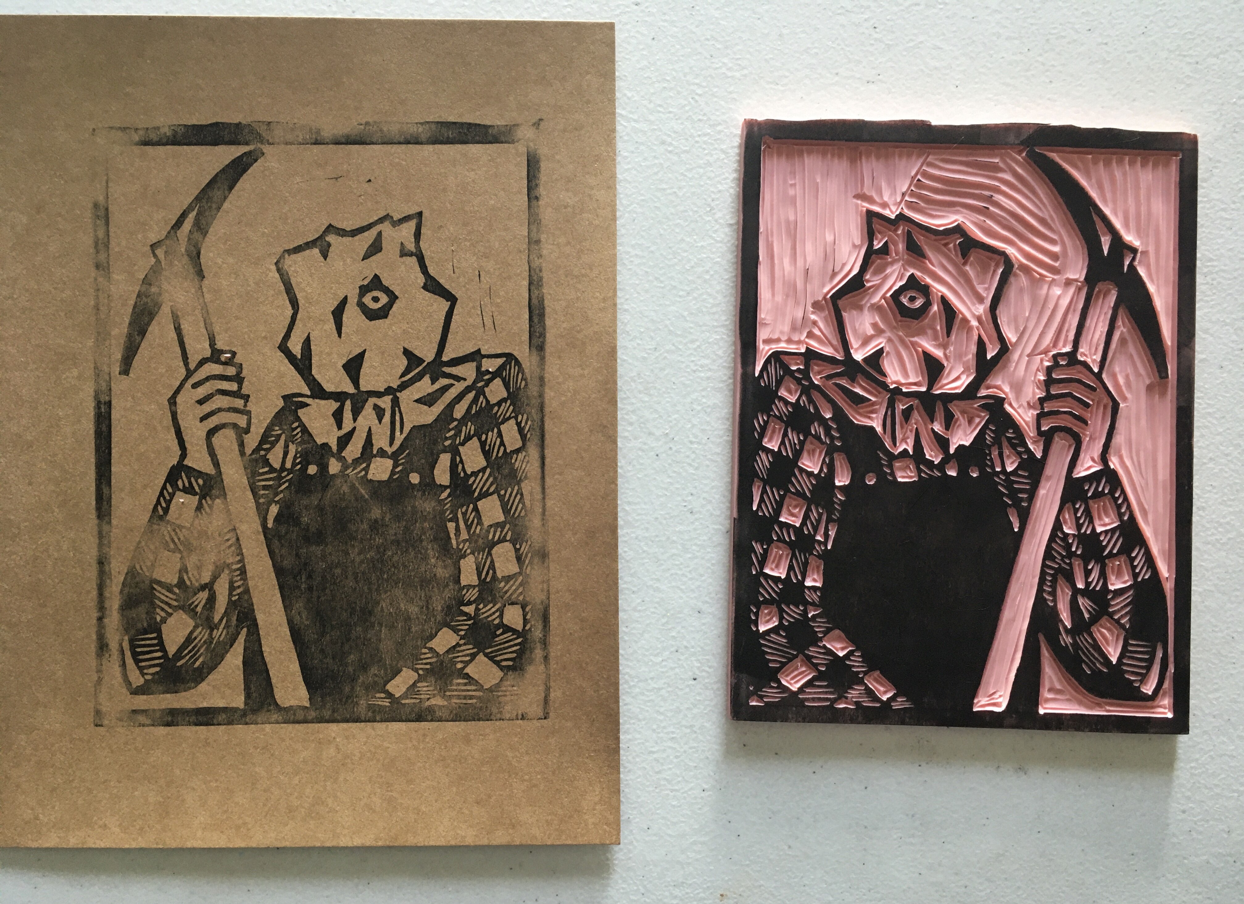 black ink blockprint on brown paper depicting jason voorhees from friday the thirteenth, part two. he has a pillowcase on his head with a hole torn out that his eye peeks through. he’s wearing a flannel shirt and overalls, and wields a pickaxe. to the left, a pink rubber block is carved with the same design, flipped horizontally